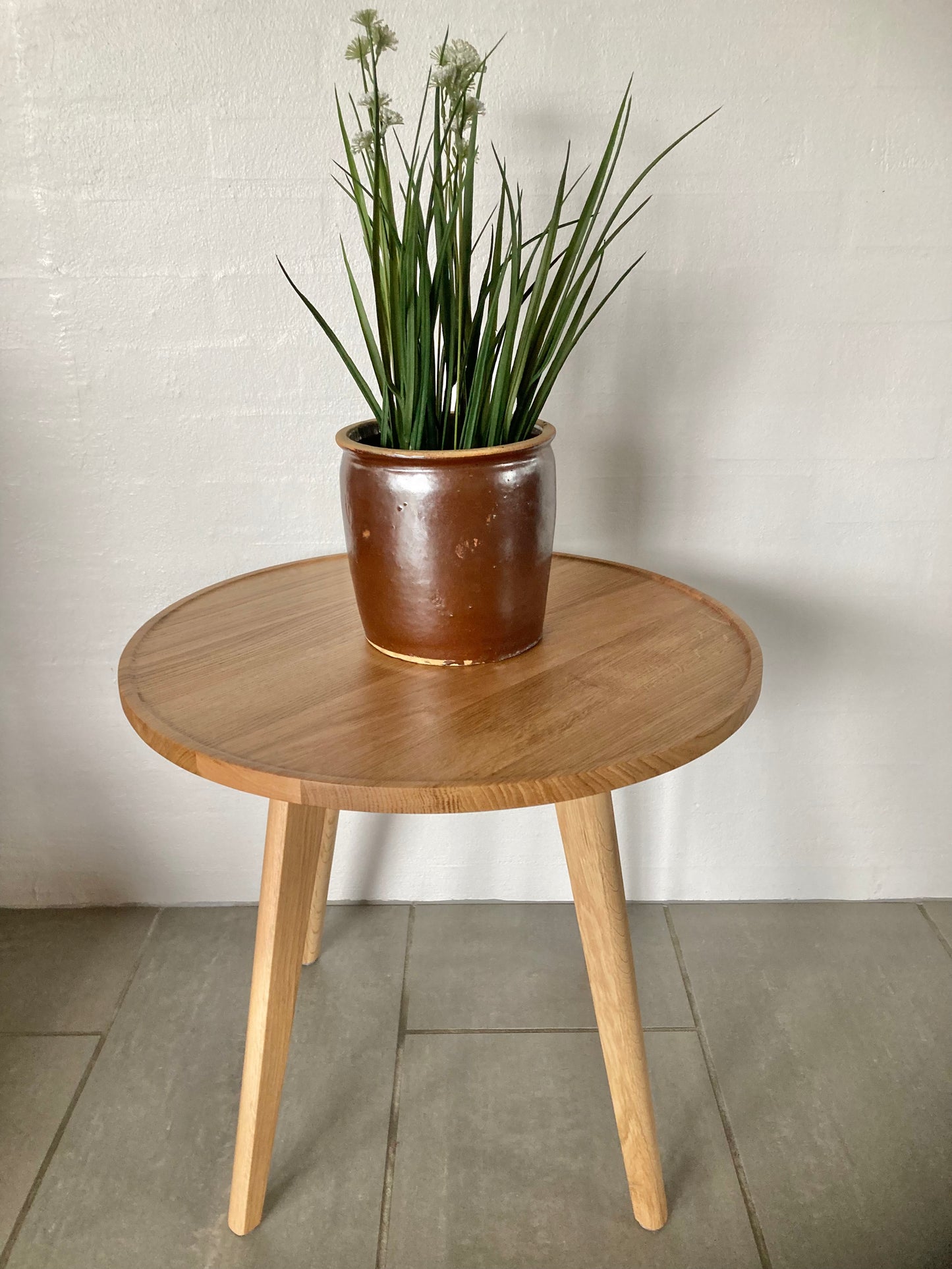 Syltekrukke der står på rundt egetræsbord.