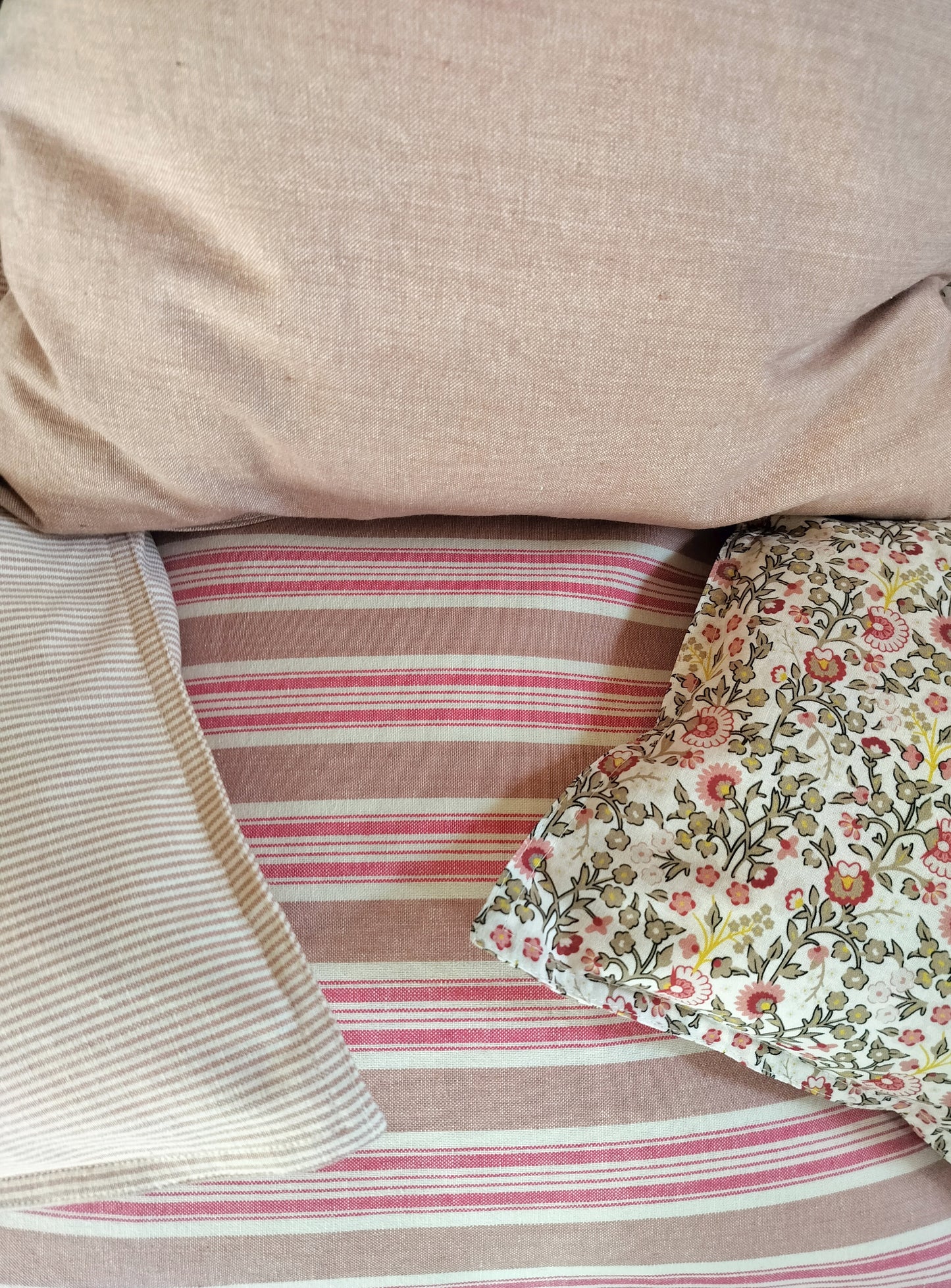 forskellige mønstrede puder i rosa nuancer.